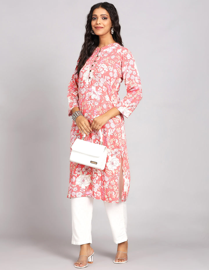 Stylish Peach Pink Long Kurti with Collar Neck Line with white pant and white transparent sandals, worn by a woman standing with white handbag.