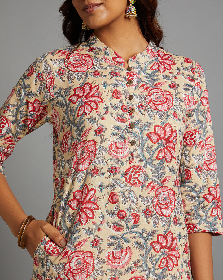 the close up view of elegant beige yellow floral print kurti with a side pocket, showing the neck design, fabric texture, neckline, wooden buttons and  stitching details. 