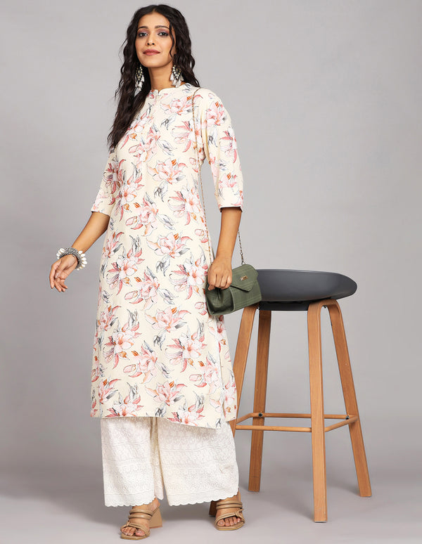 Stylish Cream Yellow Long Kurti with Collar Neck Design, paired with white palazzo and brown heels, worn by a woman standing in white table with open hair.
