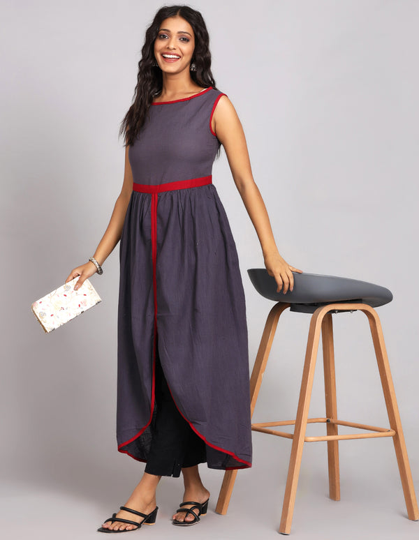 Stylish solid lack charcoal  color long kurti with, paired with black pant and black sandals, worn by a woman standing next to table.