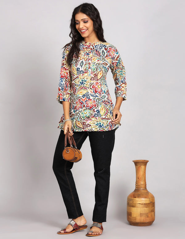 Stylish MultiColor Short Kurti with Collar Neck Line, paired with black jeans and brown slippers, worn by a woman standing next to a Pot.