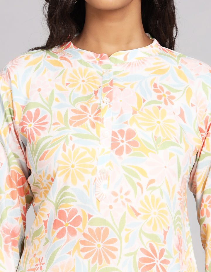 Close-up view of a multicolored short kurti top with a mandarin collar, focusing on the fabric texture, wooden buttons, and stitching details.