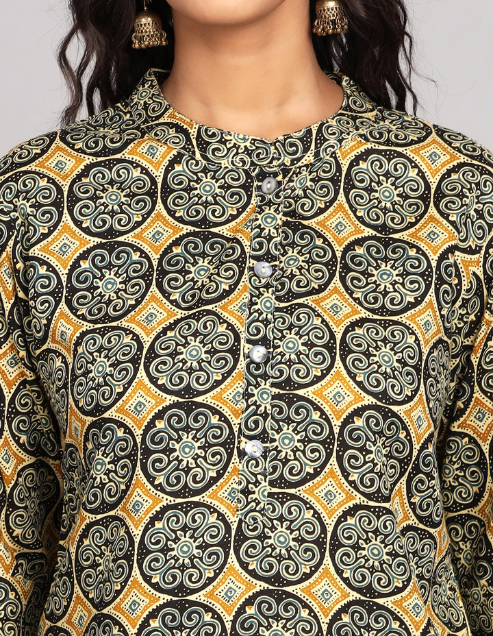 Side profile of a Rust Yellow Kurti with hand block Print with three-quarter sleeve paired with black pant and black sandals, showcasing the kurti's length and the smooth drape over the body