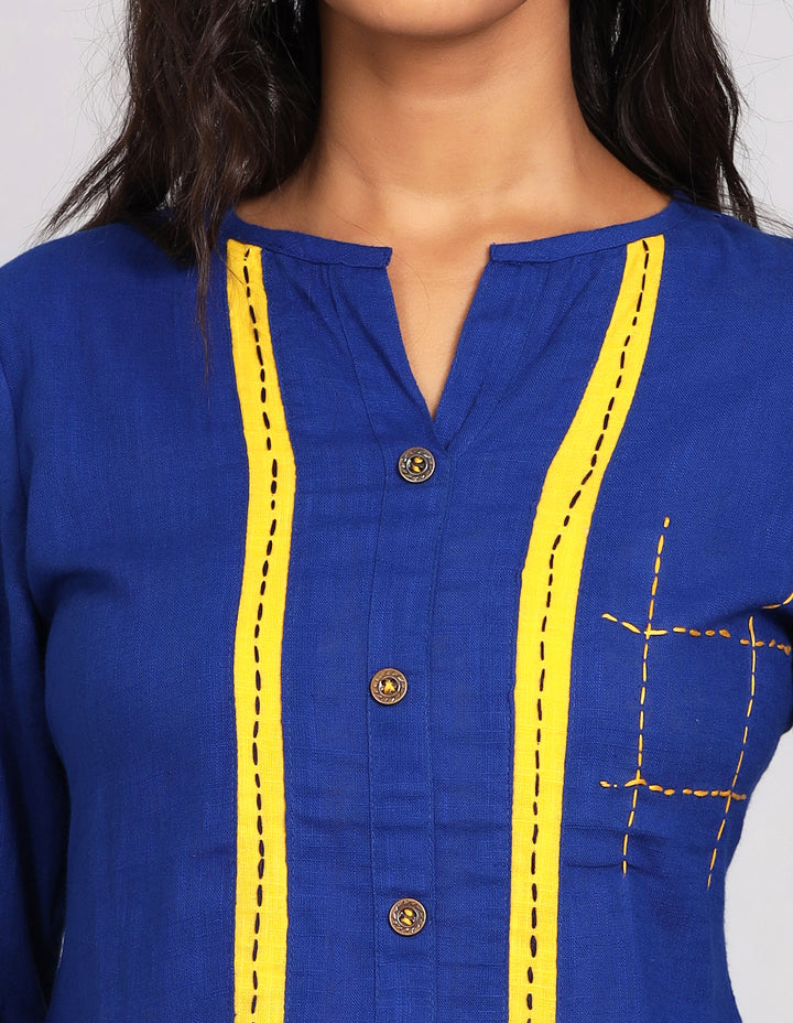 Close-up view of a royal blue button-down top with a mandarin collar, focusing on the fabric texture, wooden buttons, and stitching details.