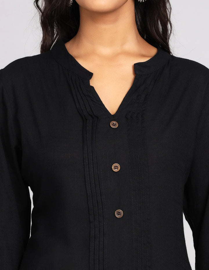 Close-up view of a black button-down top with a mandarin collar, focusing on the fabric texture, wooden buttons, and stitching details.