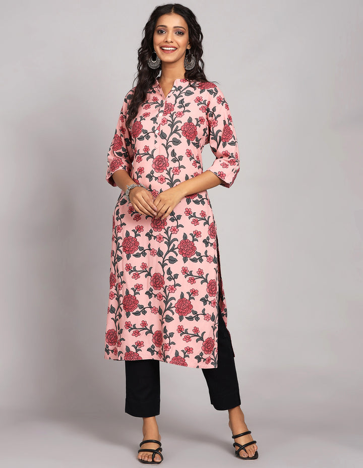 Stylish  Pink Color Floral Print Long Kurti with collar Neck design with black pant and black sandals, worn by a woman standing in white background.