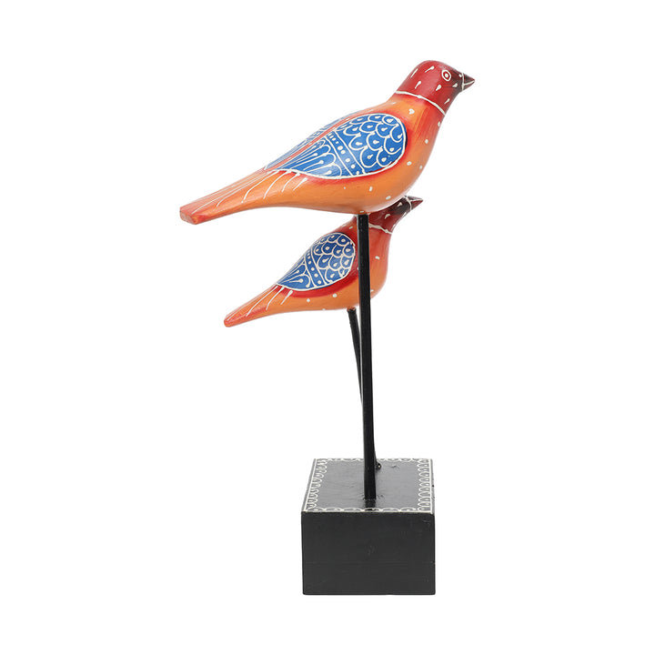 hand-crafted bird pair figurine placed at iron rod